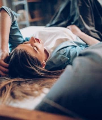 Long haired woman, lying on her back.